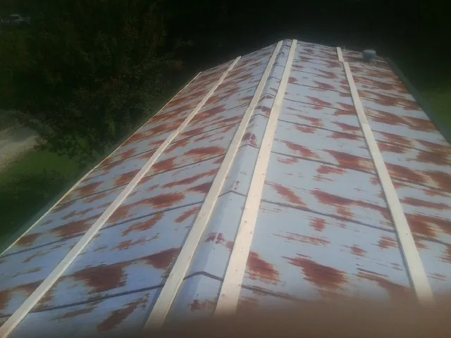 Rusted metal roof panels with new wood purlins before replacement — Storm Damage Roof Repair in Youngtown by Roofing Brothers