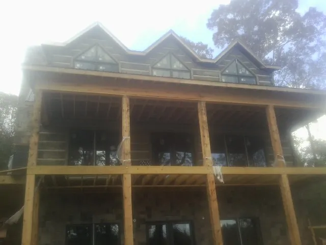 Dormers and porch framing on a large log home under construction — Roof Coating work by our crew in Youngtown