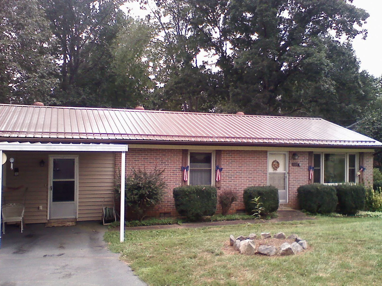Bronze metal roof and carport on a brick ranch home — Roof Repair work by our crew in Youngtown